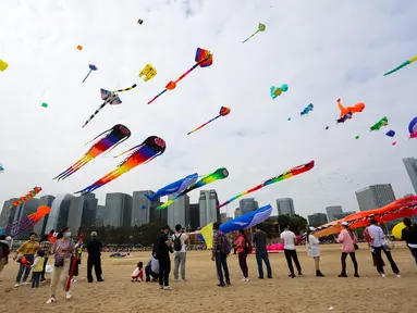 Orang-orang menerbangkan layang-layang dalam festival layang-layang di Xiamen, Provinsi Fujian, China tenggara (21/11/2020). Ratusan layang-layang diterbangkan peserta menghiasi langit wilayah China tenggara. (Xinhua/He Huan)