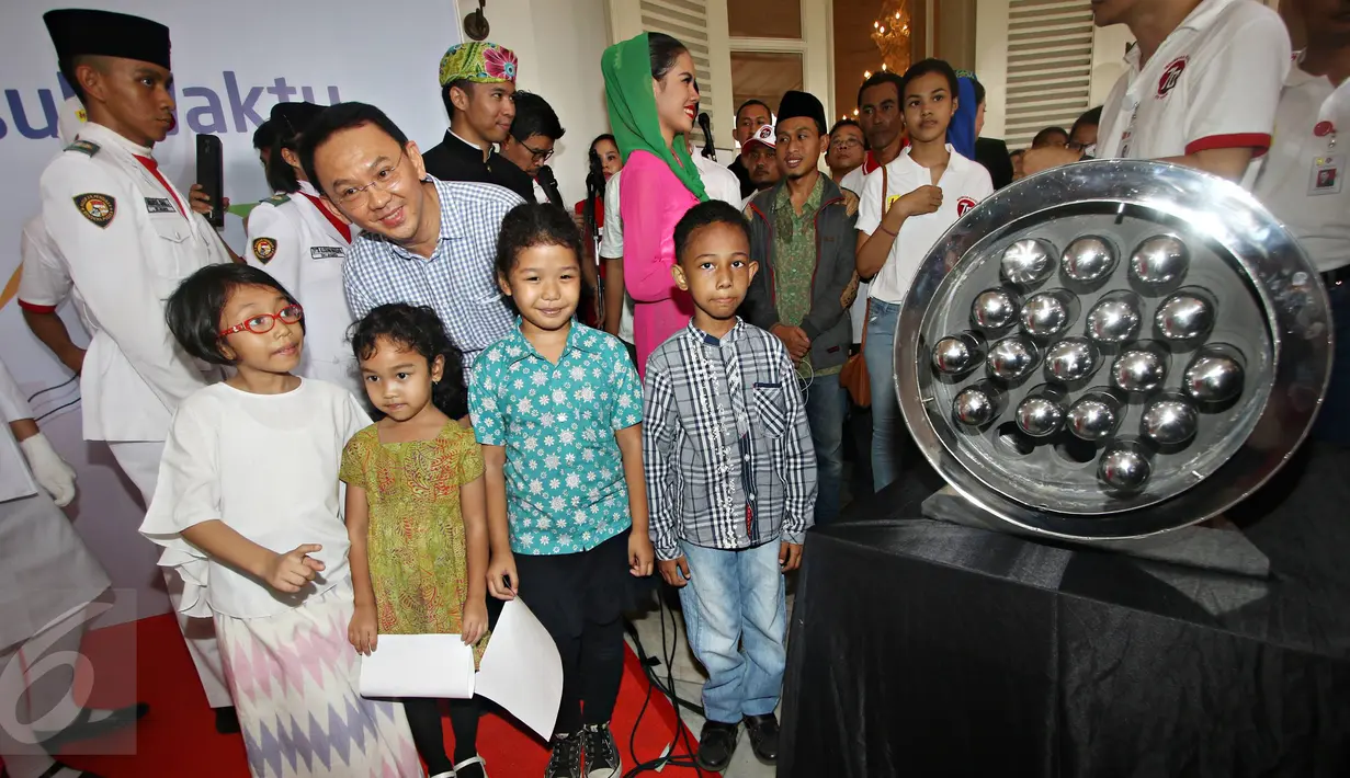 Gubernur Ahok berpose dengan sejumlah anak saat acara pelepasan mobil Kapsul Waktu untuk berkeliling Pulau Jawa, Jakarta, Sabtu (31/10/2015). Kapsul Waktu berisi kumpulan mimpi anak-anak bangsa dari Sabang sampai Merauke. (Liputan6.com/ Immanuel Antonius)