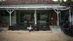 Warga menghabiskan sore mereka di bak pasir yang tersedia di hampir setiap rumah di Desa Legung Timur, Sumenep, Madura, Selasa 9 September 2025. (AP Photo/Dita Alangkara)
