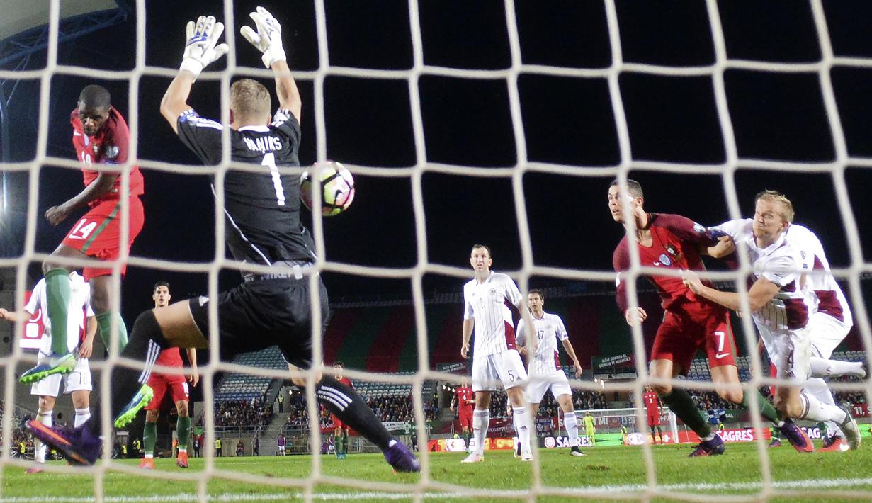 Aksi William Carvalho (kiri) menyundul bola ke gawang Latvia pada laga Kualifikasi Piala Dunia 2018 di Algarve stadium, Faro (13/11/2016). Portugal menang 4-1. (AFP/Patricia De Melo Moreira)