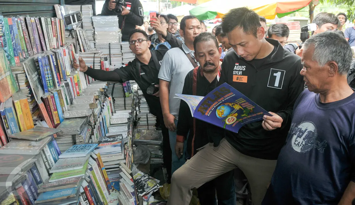 Cagub DKI Jakarta Agus Harimurti Yudhoyono melihat buku atlas yang dijual pedagang di Pasar Senen, Jakarta, Selasa (8/11). Selain meminta doa dan dukungan, Agus juga mendengarkan keluhan para pedagang Pasar Senen. (Liputan6.com/Yoppy Renato)