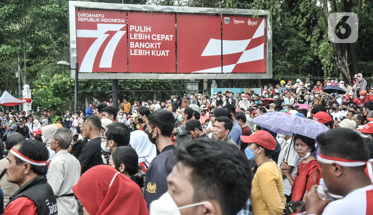 Warga melihat Upacara HUT ke-77 Republik Indonesia yang disaksikan dari Taman Aspirasi Monumen Nasional (Monas), Rabu (17/8/2022). Setelah sempat ditiadakan selama 2 tahun akibat pandemi Covid-19, Upacara Peringatan Kemerdekaan Republik Indonesia disambut antusias warga dari berbagai daerah yang berdatangan untuk mengikuti meski hanya dari luar Istana Negara. (merdeka.com/Iqbal S Nugroho)