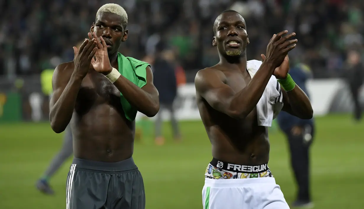Gelandang Manchester United Paul Pogba (kiri) dan bek Saint-Etienne Florentin Pogba menyapa para penonton usai pertandingan Liga Europa antara Manchester United melawan Saint-Etienne, di Stade Geoffroy-Guichard, Rabu (22/2). (PHILIPPE DESMAZES/AFP)