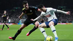 Pemain Tottenham Hotspur Son Heung-min (kanan) mencoba melewati pemain Manchester City Rodrigo pada pertandingan Liga Inggris di  Stadion Tottenham Hotspur, London, Inggris, Minggu (2/2/2020). Tottenham Hotspur mengalahkan Manchester City 2-0. (AP Photo/Ian Walton)