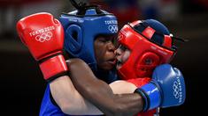 Petinju asal Jepang Tsukimi Namiki (kanan) bertarung dengan Catherine Nanziri asal Uganda dalam pertandingan tinju kelas terbang putri pada Olimpiade Tokyo 2020 di Kokugikan Arena, Tokyo, Minggu (25/7/2021). (Foto: AFP/Various Source/Luis Robayo)