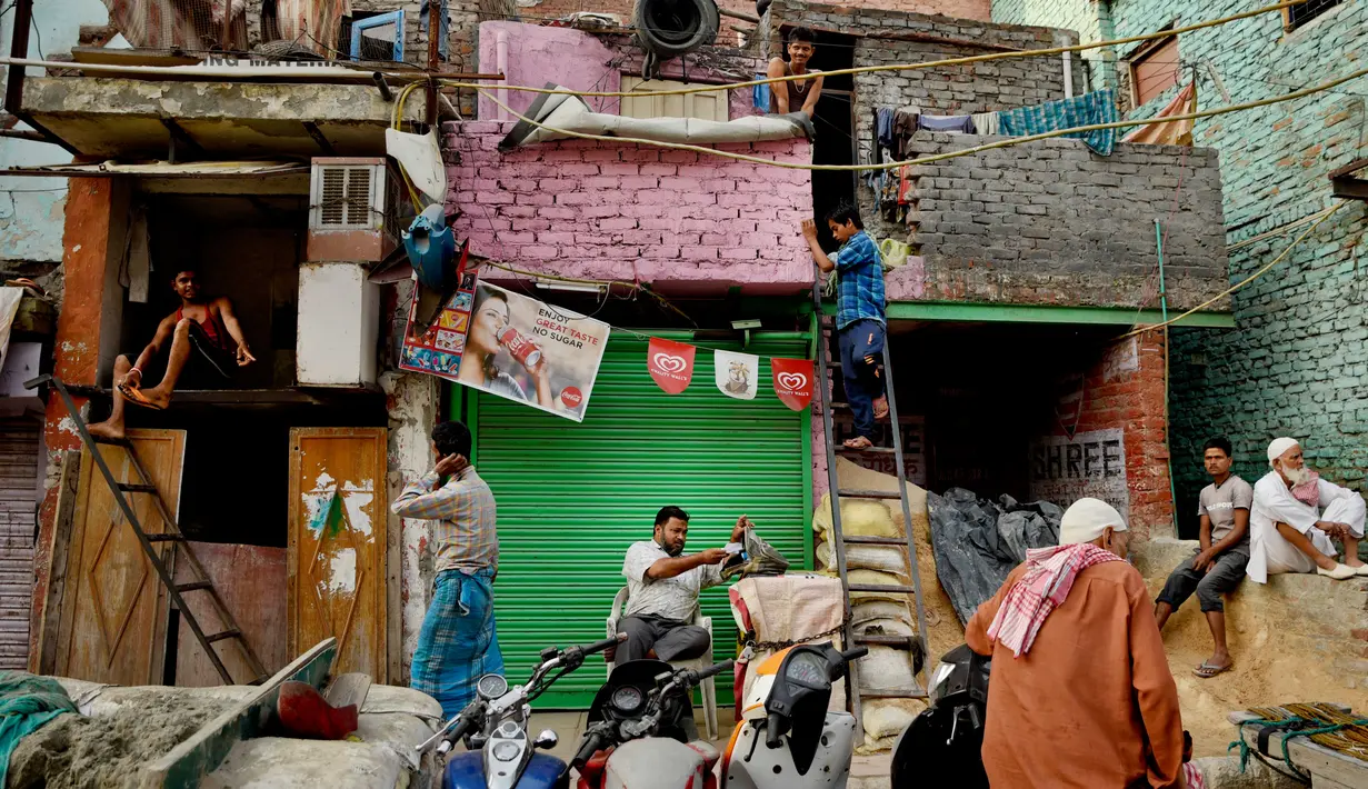 Pekerja migran dari India bagian timur bersiap di luar tempat tinggal mereka yang sempit di pondokan tuga di New Delhi, Rabu (10/10). Sekitar 800 juta warga India hidup dalam kemiskinan. (AP Photo / R S Iyer)