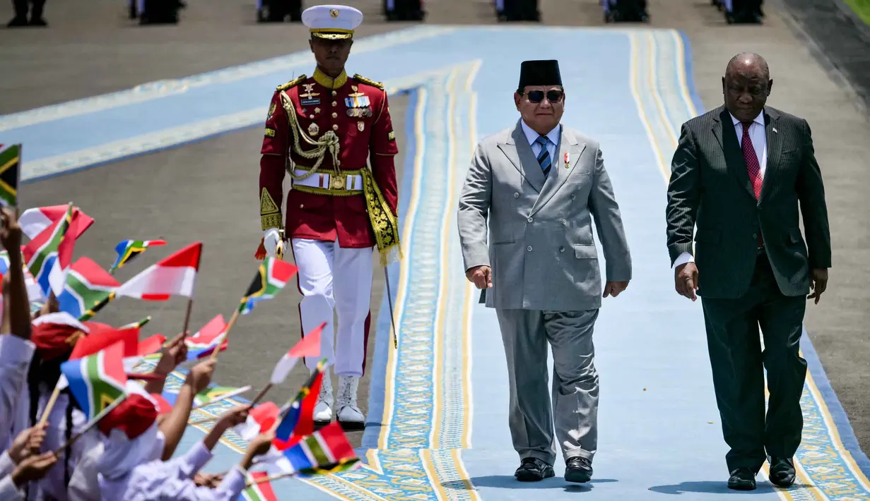 Tiba di Istana Istana Kepresidenan Republik Indonesia, disambut barisan pasukan kehormatan dan sejumlah siswa Sekolah Dasar yang mengibarkan bendera kedua negara. (Bay ISMOYO/AFP)