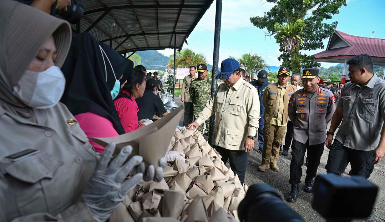 Setibanya di GOR Pandan, Prabowo langsung menuju area yang menjadi pusat koordinasi penanganan bencana. Di lokasi tersebut, Presiden meninjau dapur umum dan memastikan kebutuhan logistik masyarakat terdistribusi dengan baik. Tampak dalam foto, Presiden Republik Indonesia, Prabowo Subianto (tengah), meninjau operasional dapur umum yang menyiapkan makanan bagi para penyintas banjir bandang di posko pengungsian di Pandan, Tapanuli Tengah, Provinsi Sumatera Utara, pada 1 Desember 2025. (YT Hariono/AFP)