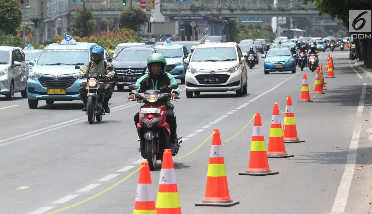 Pengendara sepeda motor melintasi di samping jalur sepeda di Jalan MH Thamrin, Jakarta, Selasa (24/9/2019). Jalur sepeda tersebut sedang dalam masa uji coba mulai 20 September hingga 19 November 2019. (Liputan6.com/Herman Zakharia)