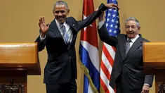 Presiden Kuba Raul Castro mengangkat tangan Presiden AS Barack Obama usai konferensi pers di Istana Revolusi, Havana, Senin (21/3). Obama menjadi presiden pertama AS yang berkunjung ke negara komunis itu sejak 88 tahun terakhir. (REUTERS/Carlos Barria)