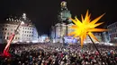 Ribuan orang menonton vespers Natal tradisional di luar gereja Frauenkirche, Church of Our Lady, di Dresden, Jerman (23/12). (Sebastian Kahnert / dpa via AP)