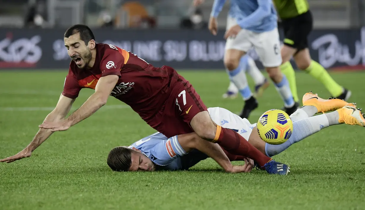 Gelandang AS Roma Henrikh Mkhitaryan (atas) bertabrakan dengan gelandang Lazio, Sergej Milinkovic-Savic dalam pekan ke-18 Liga Italia di Stadion Olimpiade Roma, Sabtu (16/1/2021) dini hari WIB. AS Roma dibantai 0-3 oleh Lazio dalam laga bertajuk Derby della Capitale. (Filippo MONTEFORTE/AFP)