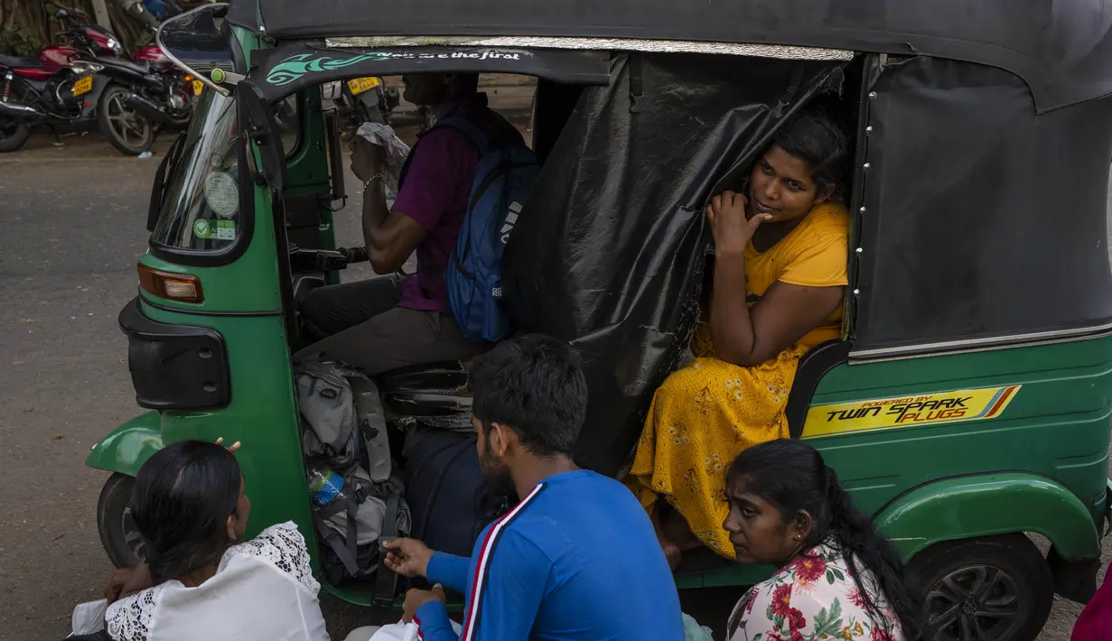 <p>Seorang gadis duduk di becak saat bersama dengan yang lain menunggu dalam antrean untuk mendapatkan paspor mereka di luar Departemen Imigrasi &amp; Emigrasi di Kolombo, Sri Lanka, Senin (18/7/2022). Negara kepulauan Samudra Hindia itu dilanda krisis ekonomi yang belum pernah terjadi sebelumnya yang telah memicu ketidakpastian politik. (AP Photo/Rafiq Maqbool)</p>