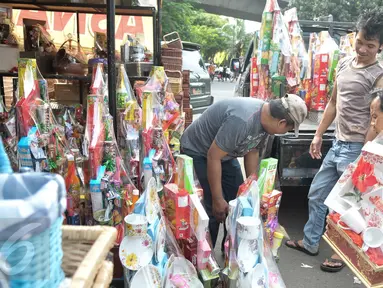 Pedagang menaikan parcel ke atas mobil di kawasan Pasar kembang, Cikini, Jakarta, Jumat (16/12). Jelang hari raya Natal, pedagang parcel di kawasan Cikini masih sepi pembeli. (Liputan6.com/Yoppy Renato)