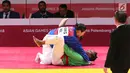 Atlet beladiri Kurash Indonesia, Marselina Papara saat bertarung dengan Munkhtstsg Ogon dari Monggolia di 16 besar kelas putri dibawah 78 kg di JCC Senayan, Jakarta, Kamis (30/8). Indonesia kalah 0-10 dari Monggolia. (Liputan6.com/Fery Pradolo)