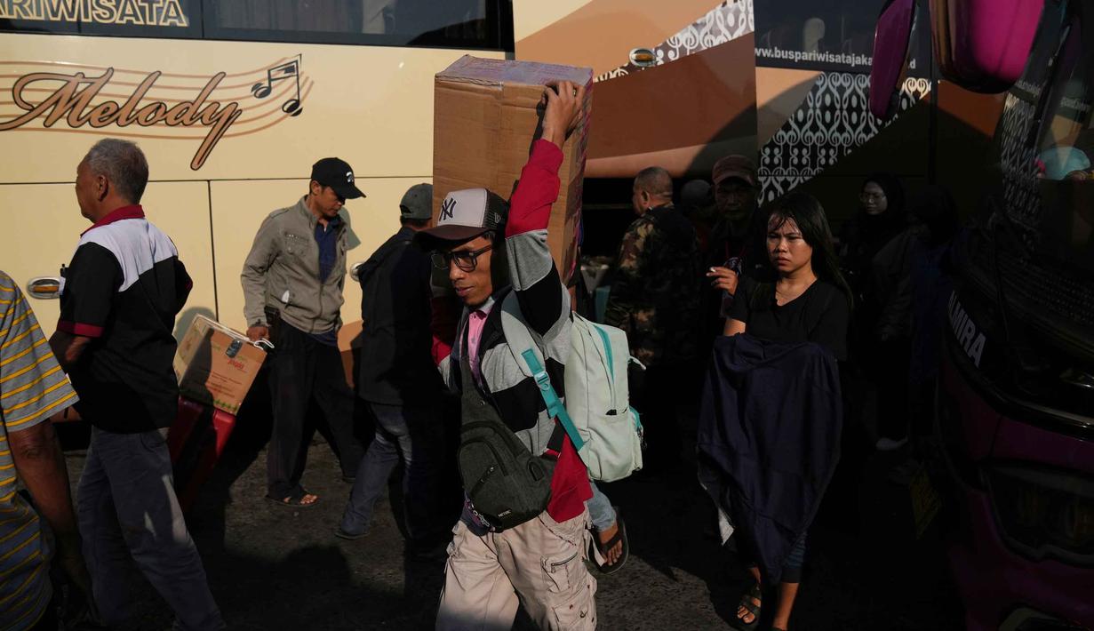 Nur Prasetyo menambahkan, total dari H-8 sampai H-3 sekitar 7.000 sampai 8.000 penumpang. Tampak dalam foto, para calon penumpang membawa barang-barang mereka di terminal bus untuk pulang ke kampung halaman menjelang libur Idul Fitri 1447 Hijriah sekaligus menandai berakhirnya bulan suci puasa Ramadan, di terminal Terminal Kalideres, Jakarta, Rabu 18 Maret 2026. (AP Photo/Dita Alangkara)