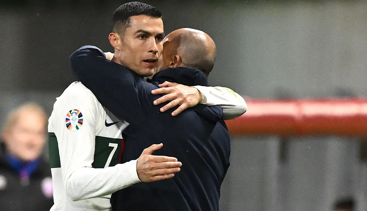 Striker Timnas Portugal, Cristiano Ronaldo memeluk pelatih Roberto Martinez setelah ia ditarik keluar untuk digantikan oleh Bruma pada laga lanjutan Grup J Kualifikasi Euro 2024 di Rheinpark Stadium, Vaduz, Jumat (17/11/2023) dini hari WIB. (AFP/Sebastien Bozon)