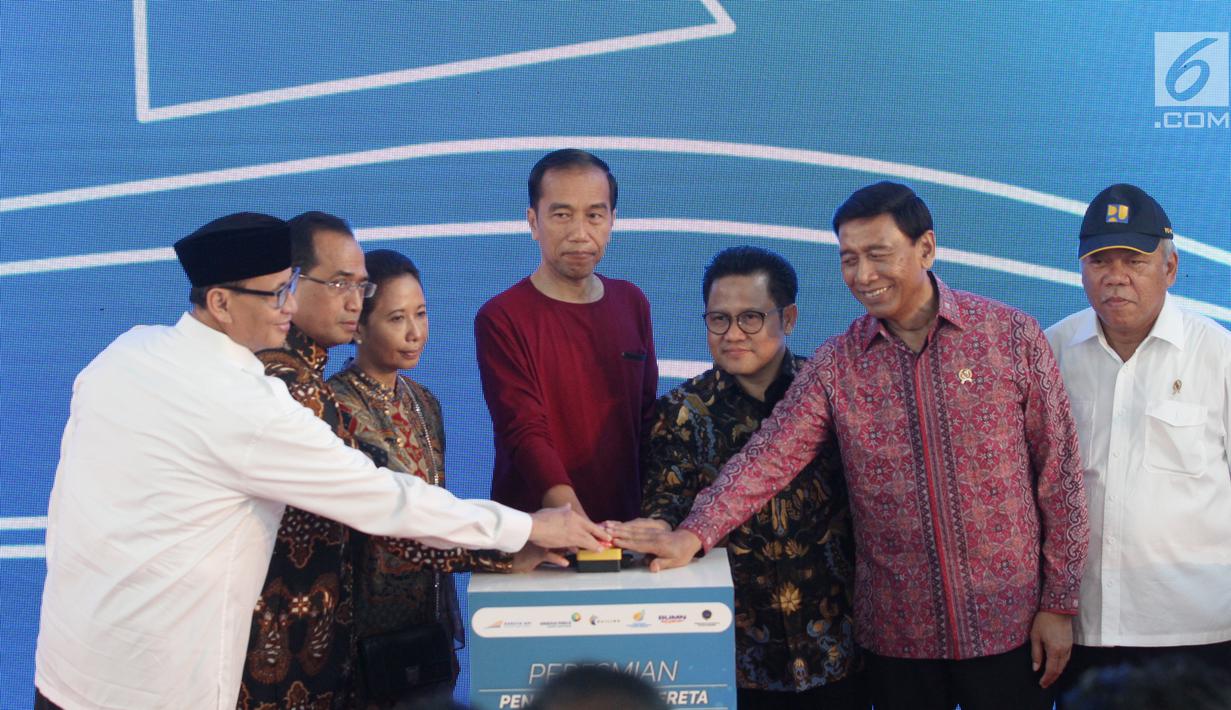 Presiden Jokowi (tengah) didampingi sejumlah menteri dan Ketum PKB, Muhaimin Iskandar menekan tombol saat peresmian Stasiun Bandara Soekarno-Hatta (2/1). (Liputan6.com/Pool)