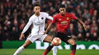 Aksi Marcus Rashford mencoba melewati Marquinhos pada laga leg 1, babak 16 Besar Liga Champions yang berlangsung di Stadion Old Trafford, Manchester, Rabu (13/2).  Manchester United kalah 0-2 dari PSG. (AFP/Paul Ellis)