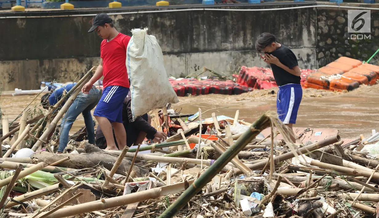 Sejumlah anak mencari botol-botol plastik yang tersangkut diantara tumpukan sampah di Pintu Air Manggarai, Jakarta, Jumat (26/4). Selanjutnya, botol-botol plastik bekas minuman kemasan ini akan dijual ke pengepul. (Liputan6.com/Helmi Fithriansyah)