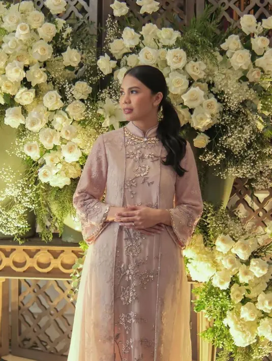 Sedangkan, Rachelly mengenakan dress pink panjang yang memiliki warna pink dengan kerah semi tinggi. Dress tersebut nampak mewah dengan bordiran dan payet motif floral dengan aksen organza pada bagian depan. [@rachellyahya]