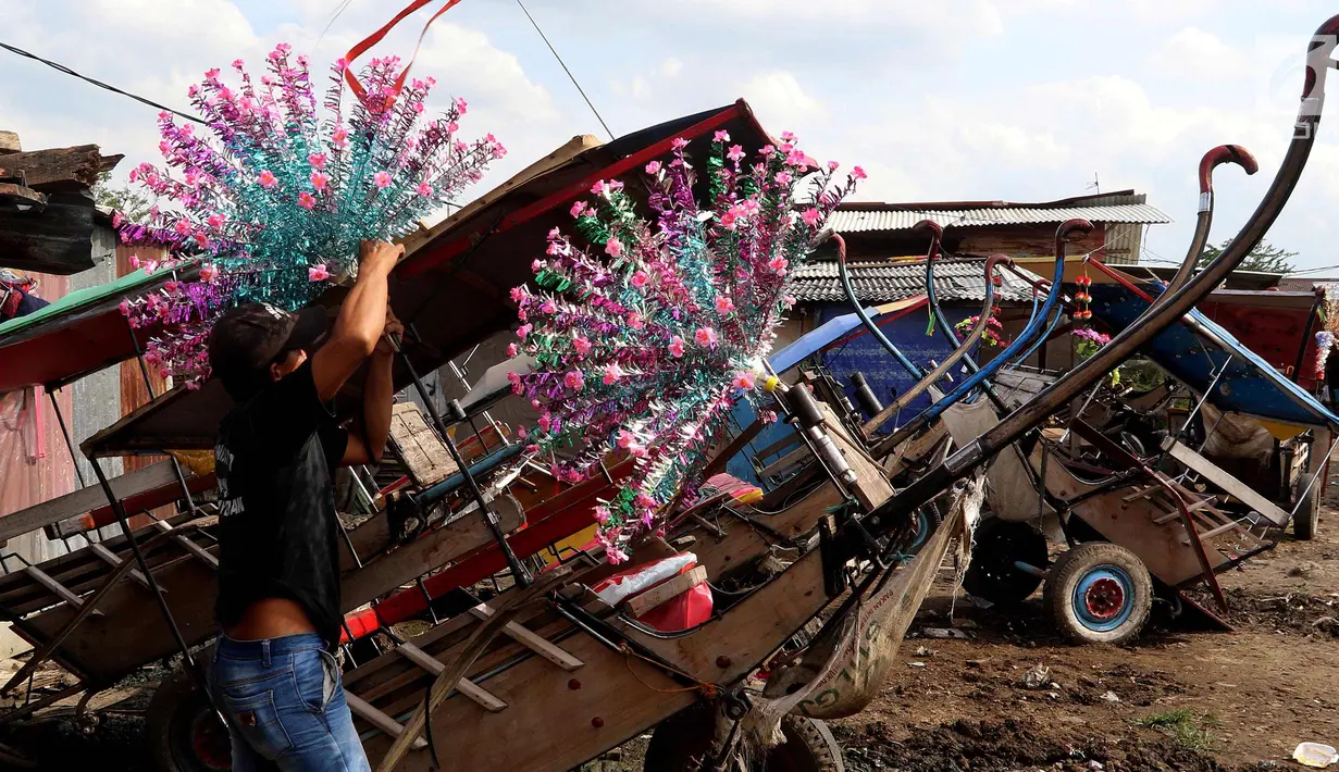 Kusir menyiapkan hiasan andong di Kelurahan Jatinegara, Kec Cakung, Jakarta, Sabtu (27/1). Dengan menarik andong setiap harinya rata-rata kusir mendapatkan antara 30 - 100 ribu perharinya untuk menghidupi keluarganya. (Liputan6.com/Johan Tallo)