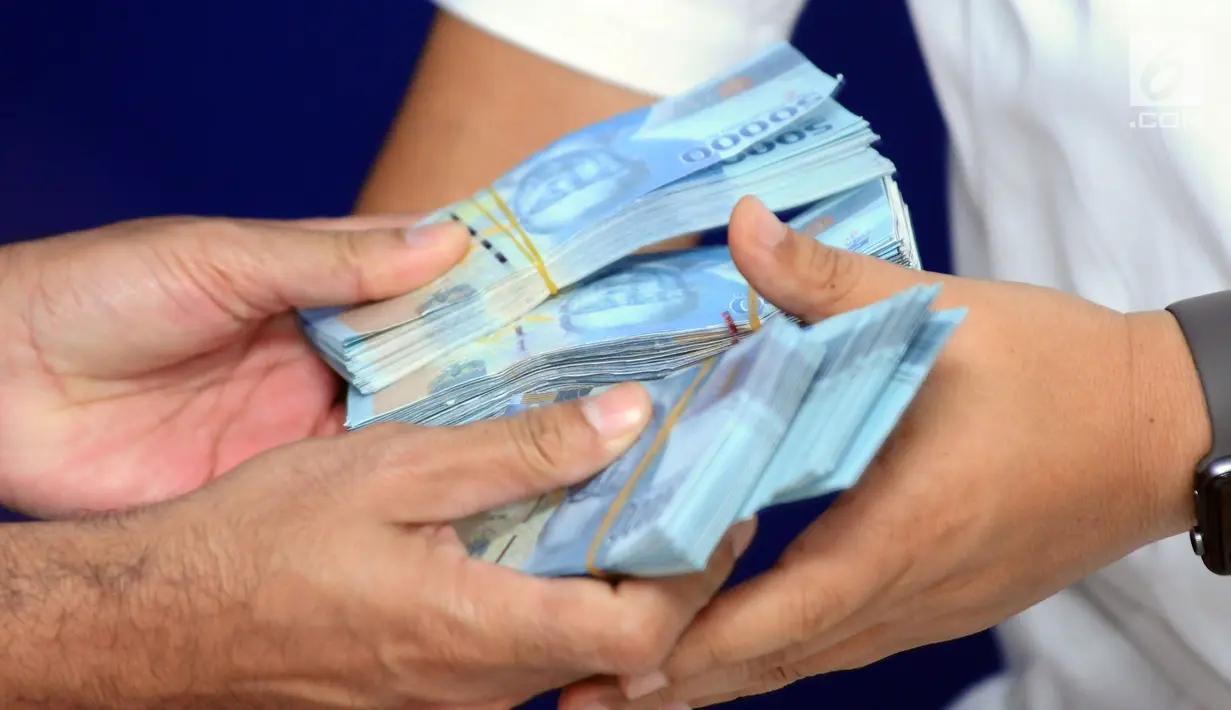 Petugas memperlihatkan uang palsu pecahan Rp 50.000,- emisi tahun 2016 saat rilis di Bareskrim Polri, Jakarta, Senin (29/1). Dirtidpid Ekonomi dan Khusus Bareskrim Polri menangkap empat tersangka di wilayah Cikarang. (Liputan6.com/Helmi Fithriansyah)