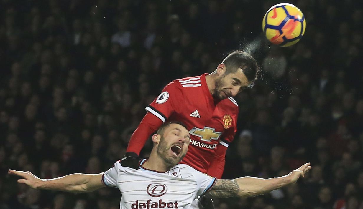 Pemain Manchester United, Henrikh Mkhitaryan (atas) berduel dengan pemain Burnley, Phil Bardsley (L) pada lanjutan Premier League di Old Trafford,  Manchester (26/12/2017).  MU bermain imbang 2-2. (AFP/Lindsey Parnaby)
