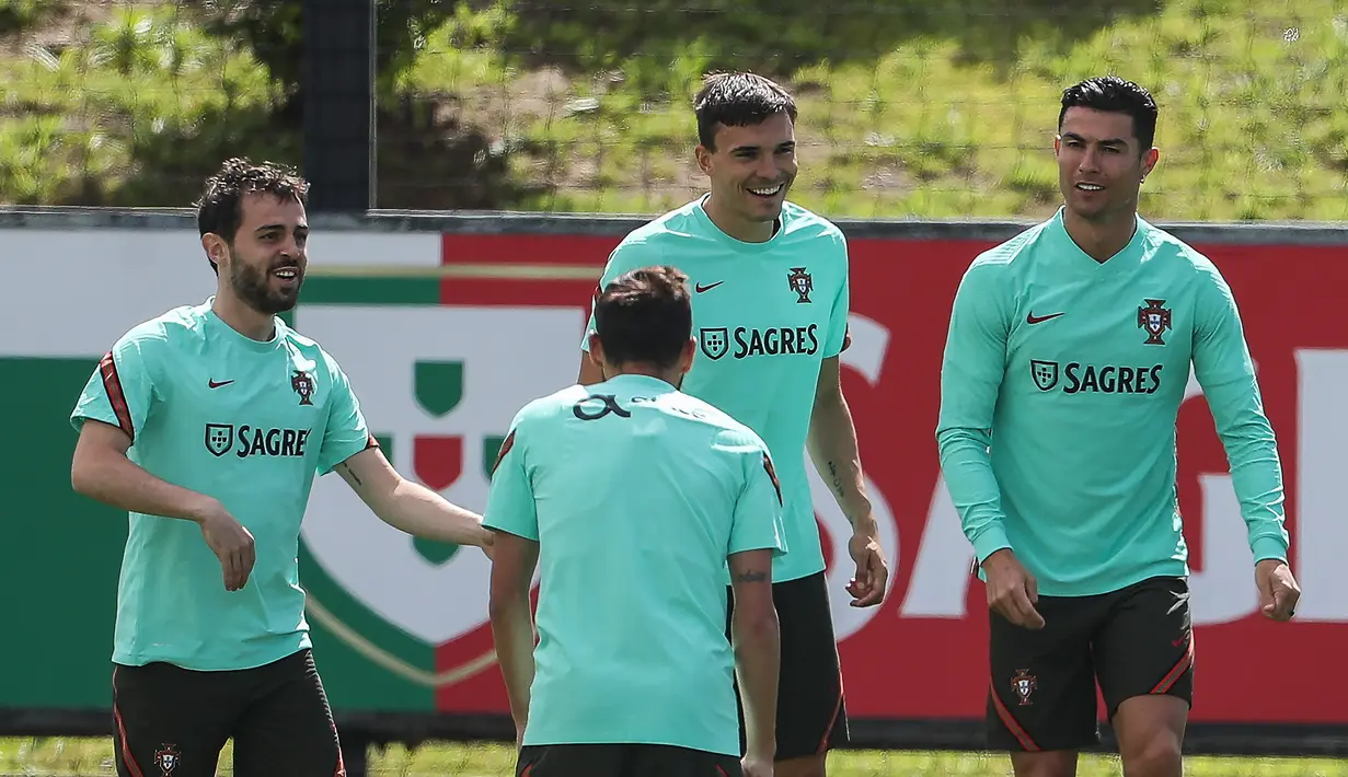 (Dari kiri) Pemain timnas Portugal Bernardo Silva, Joao Palhinha dan Cristiano Ronaldo mengambil bagian dalam sesi latihan di kamp pelatihan "Cidade do Futebol" Portugal di Oeiras, di pinggiran Lisbon, Sabtu (4/6/2022). Portugal akan menjamu Swiss pada matchday 2 Grup 2 UEFA Nations League A 2022/2023, Senin 6 Juni 2022 dini hari WIB di Estadio Jose Alvalade. (CARLOS COSTA / AFP)