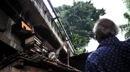 Warga memberi makan burung dara yang diternak di kolong jembatan, Jakarta, Kamis (14/2). Kolong jembatan tersebut digunakan oleh warga setempat untuk menernak hewan dan membuat arang akibat kurangnya lahan. (Merdeka.com/Iqbal S. Nugroho)