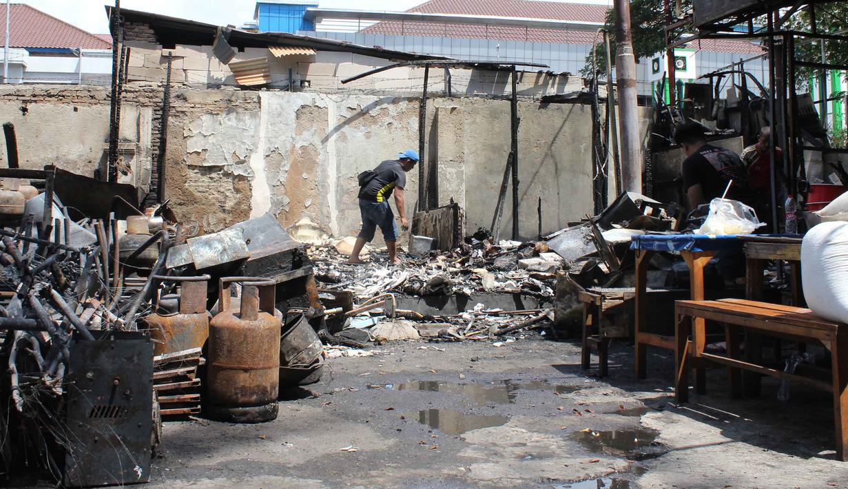Kebakaran dipicu kericuhan pasca pengeroyokan yang melibatkan mata elang (sebutan untuk penagih utang di lapangan) dengan orang tidak dikenal yang terjadi di kawasan Kalibata, Jakarta Selatan pada Kamis (11/12/2025) sore. Tampak dalam foto, pemilik kios membersihkan puing-puing bangunan usai kebakaran yang melanda deretan kios di kawasan Kalibata, Jakarta Selatan, pada Jumat (12/12/2025). (merdeka.com/magang/Rendi Saputra)