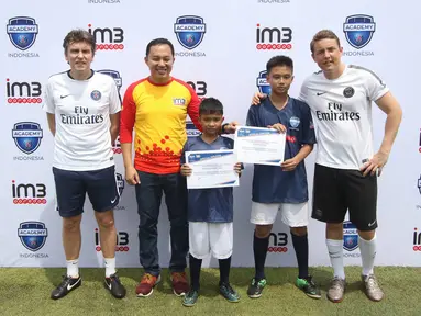  Technical Director of PSG Academy Cedric Cattenoy (kiri), Head Coach PSG Academy Benjamin Houri (kanan) dan Division Head Consumer Engagement Indosat Ooredoo Benny Hutagalung berfoto bersama anak-anak, Jakarta, (3/4). (Liputan6.com/Immanuel Antonius)