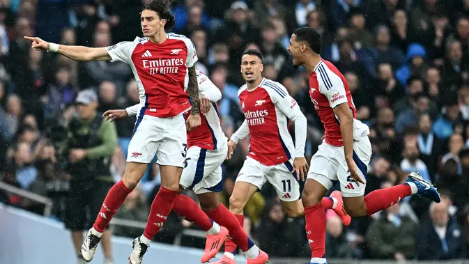 Bek Arsenal, Riccardo Calafiori, merayakan gol yang dicetaknya ke gawang Manchester City dalam laga pekan kelima Premier League 2024/2025 di Etihad Stadium, Minggu (22/9/2024) malam WIB. (Paul ELLIS / AFP)