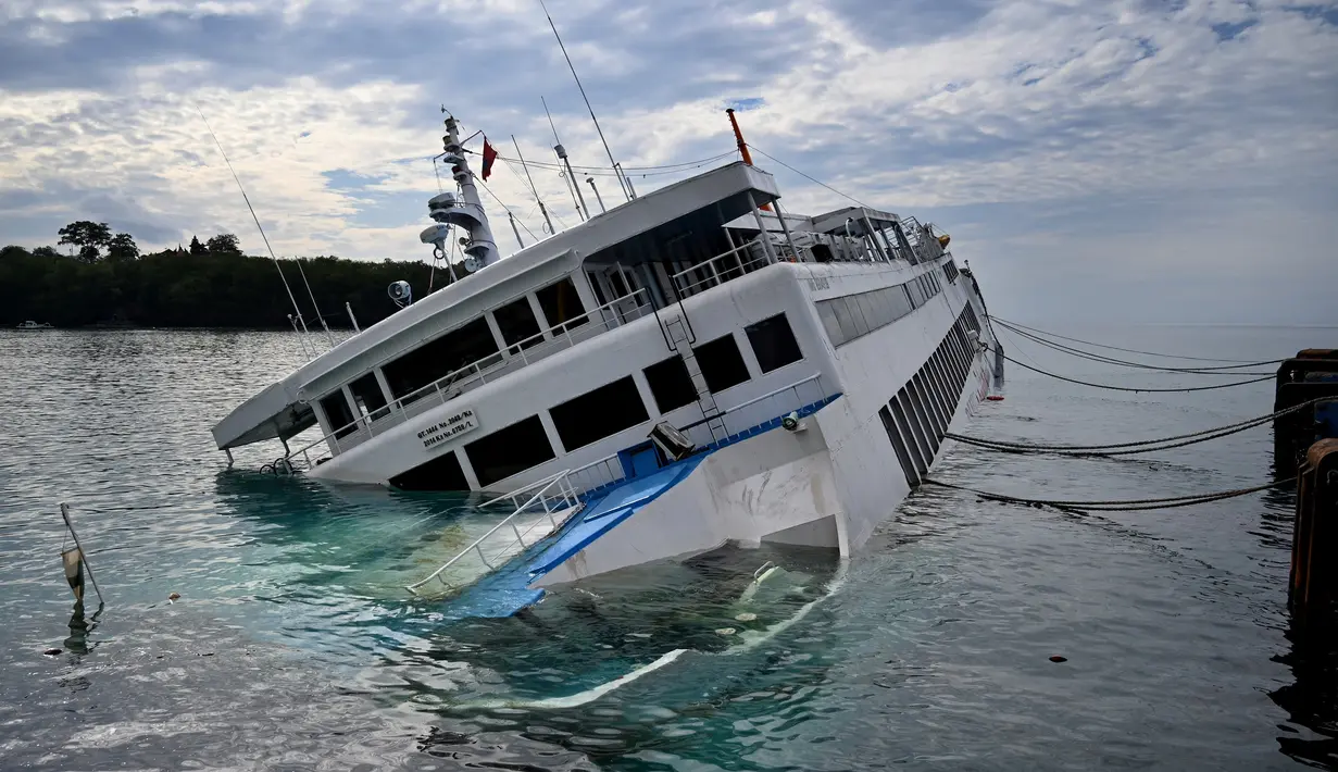 KMP Dharma Rucitra III kandas di Pelabuhan Padang Bai, Karangasem, Bali, Sabtu (13/6/2020). Ada 60 penumpang yang berhasil dievakuasi. (SONNY TUMBELAKA/AFP)