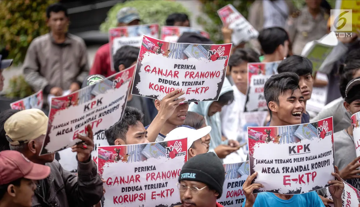 Peserta aksi menunjukkan poster saat menggelar unjuk rasa di depan Gedung KPK, Jakarta, Rabu (29/11). Dalam aksinya mereka menuntut KPK segera menyeret para penikmat kasus e-KTP tanpa pandang bulu. (Liputan6.com/Faizal Fanani)