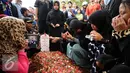 Keluarga berdoa di sisi makam Achmad Kurniawan di TPU Cijantung, Jakarta, Rabu (11/1). Kiper Arema FC, Achmad Kurniawan wafat di usia 37 tahun. (Liputan6.com/Helmi Fithriansyah)