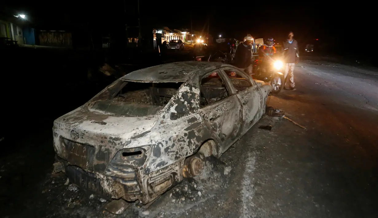 Sebuah mobil hangus terbakar usai terjadi tabrakan dengan mobil tangki pembawa gas kimia di Kenya, Minggu (11/12). Dikabarkan lebih dari 30 orang tewas dalam peristiwa nahas tersebut. (REUTERS / Stringer)