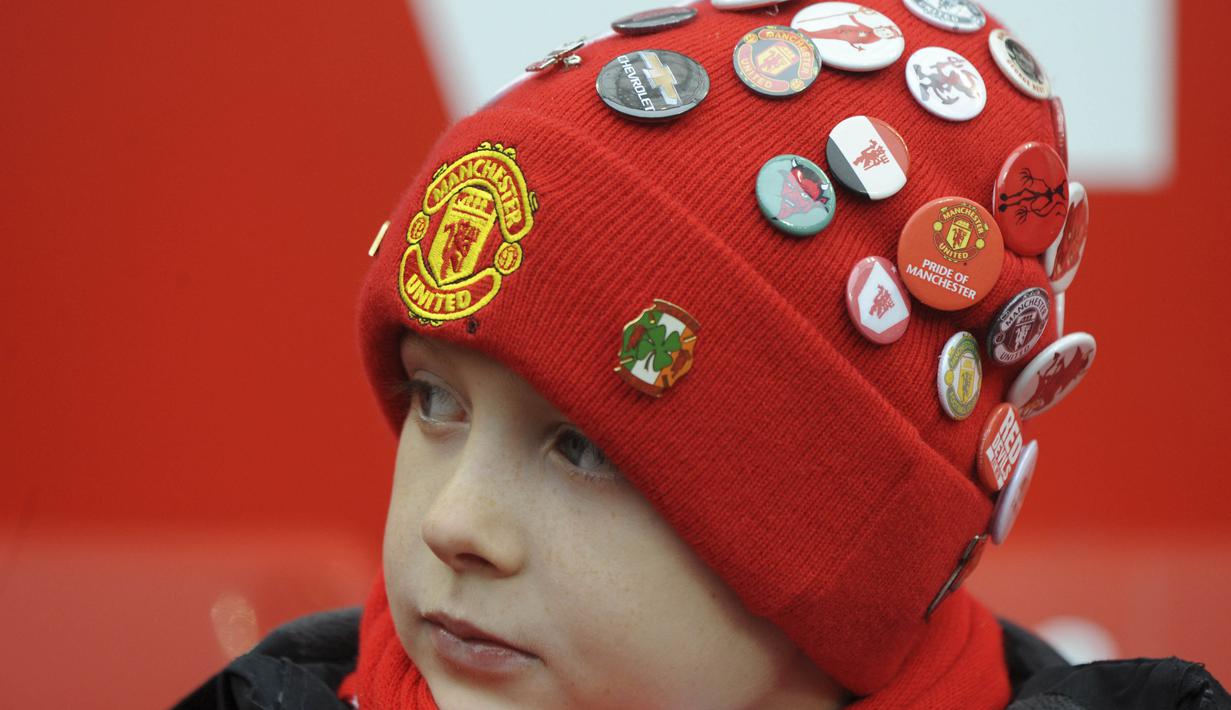 Fans cilik Manchester United dengan topi yang penuh dengan pin tim kesayangannya Setan Merah serius menyaksi laga Piala FA di Old Trafford, (7/1/2017). Setan Merah menang 4-0. (AP/Rui Vieira)