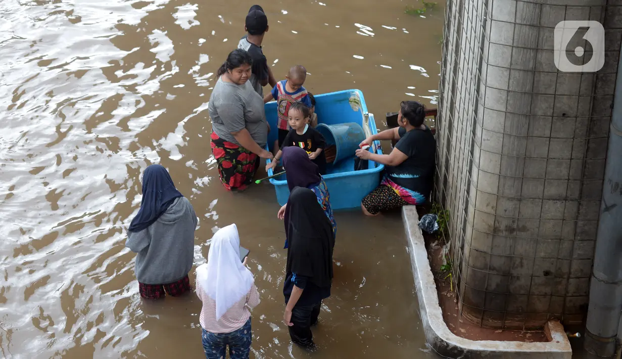 Warga menyusuri banjir yang merendam Jalan Kapten Tendean, Jakarta, Sabtu (20/2/2021).  Banjir yang disebabkan curah hujan tinggi memutus akses lalu lintas di Jalan Kapten Tendean. (merdeka.com/Imam Buhori)