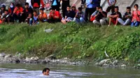 Panji Petualang loncat ke Sungai Palu, Sulawesi Tengah, untuk memastikan ada tidaknya buaya berkalung ban. (Foto: Dite Surendra/Jawa Pos)