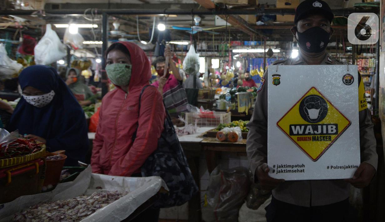 Petugas Polres Jakarta Timur melakukan sosialisasi dan membagikan masker di Pasar Palmeriam, Matraman, Selasa (9/2/2021). Kegiatan itu dilakukan sebagai upaya meningkatkan kesadaran masyarakat akan pentingnya penerapan protokol kesehatan untuk menekan penyebaran Covid-19. (merdeka.com/Imam Buhori)