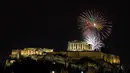 Kembang api meledak di atas kuil kuno Parthenon di Bukit Acropolis saat perayaan Tahun Baru di Athena, Yunani, Senin (1/1/2024). (AP Photo/Yorgos Karahalis)