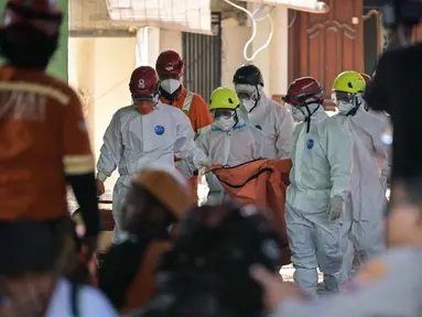 Tim pencari dan penyelamat membawa kantong jenazah dari lokasi runtuhnya bangunan musala di Pondok Pesantren Al Khoziny di Sidoarjo, Jawa Timur, pada 6 Oktober 2025. (JUNI KRISWANTO/AFP)