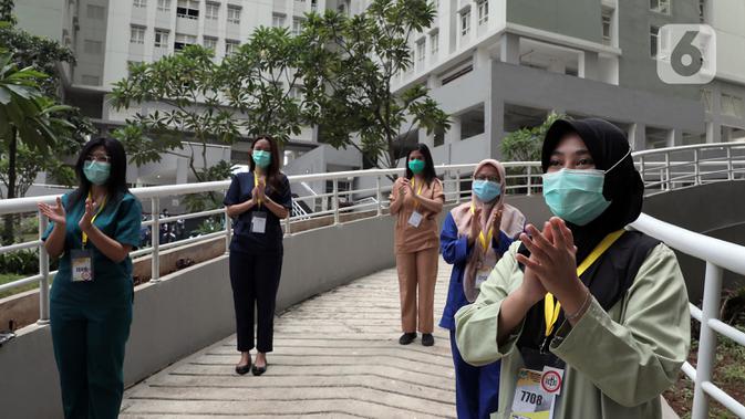Tenaga kesehatan bertepuk tangan selama 56 detik pada peringatan Hari Kesehatan Nasional ke-56 di RSD Wisma Atlet, Jakarta, Kamis (12/11/2020). Aksi tersebut sebagai bentuk penghargaan kepada tenaga kesehatan yang berjuang menghadapi pandemi COVID-19. (Liputan6.com/Herman Zakharia)