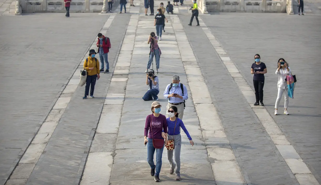 Para pengunjung mengenakan masker saat berjalan di Kota Terlarang, Beijing, China, Jumat (1/5/2020). Kota Terlarang kembali dibuka setelah ditutup lebih dari tiga bulan karena pandemi virus corona COVID-19. (AP Photo/Mark Schiefelbein)