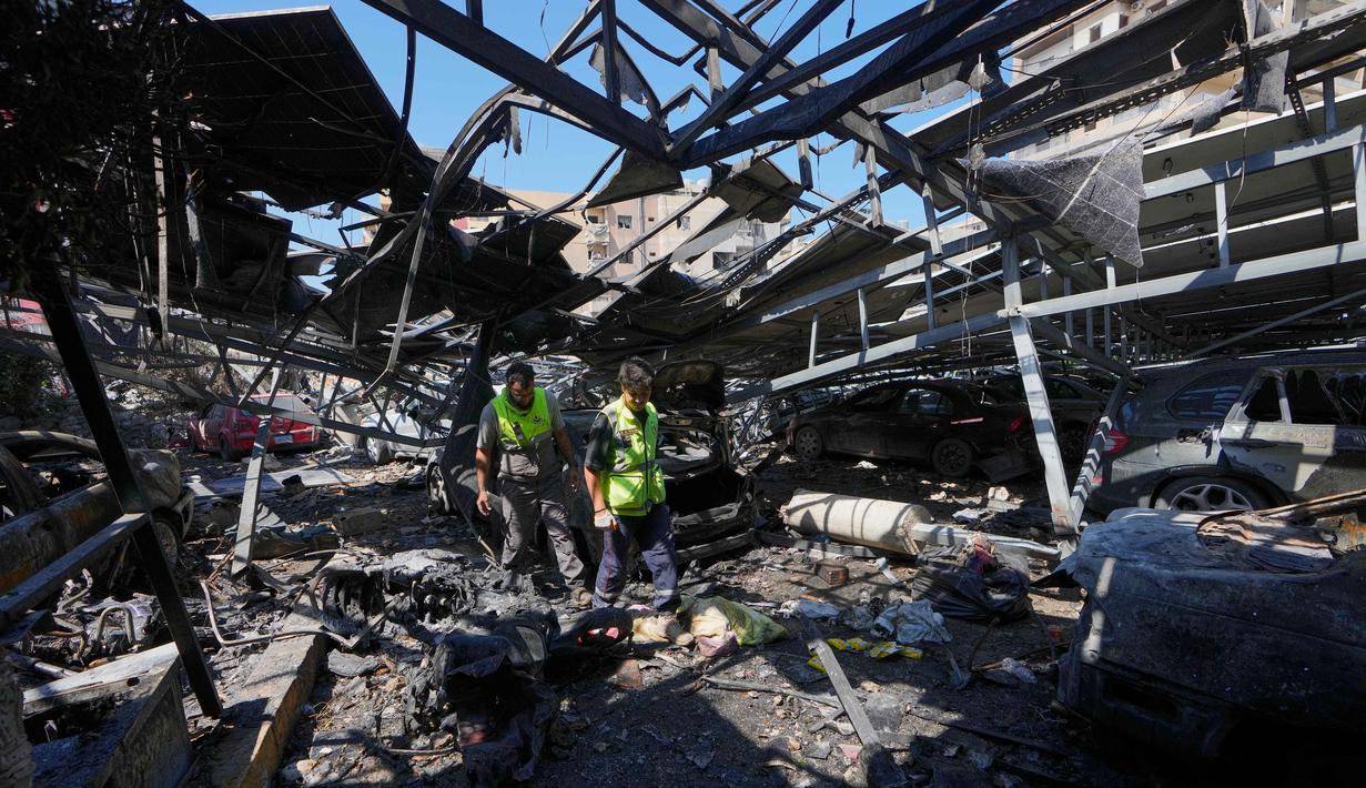 Petugas penyelamat memeriksa kerusakan area parkir Rumah Sakit Jabal Amel, menyusul serangan udara Israel pada Senin (1/6) yang menghantam gedung di dekatnya, di kota pelabuhan selatan Tyre, Lebanon, Selasa 2 Juni 2026. (AP Photo/Mohammed Zaatari)