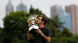 Petenis Swiss, Roger Federer mencium piala Challenge Norman Brookes di Government House, Melbourne, Australia (29/1). Federer mengalahkan petenis Kroasia Marin Cilic 6-2, 6-7(5), 6-3, 3-6, 6-1. (AP Photo/Ng Han Guan)
