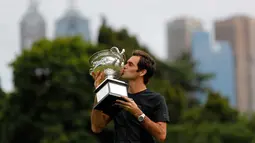 Petenis Swiss, Roger Federer mencium piala Challenge Norman Brookes di Government House, Melbourne, Australia (29/1). Federer mengalahkan petenis Kroasia Marin Cilic 6-2, 6-7(5), 6-3, 3-6, 6-1. (AP Photo/Ng Han Guan)