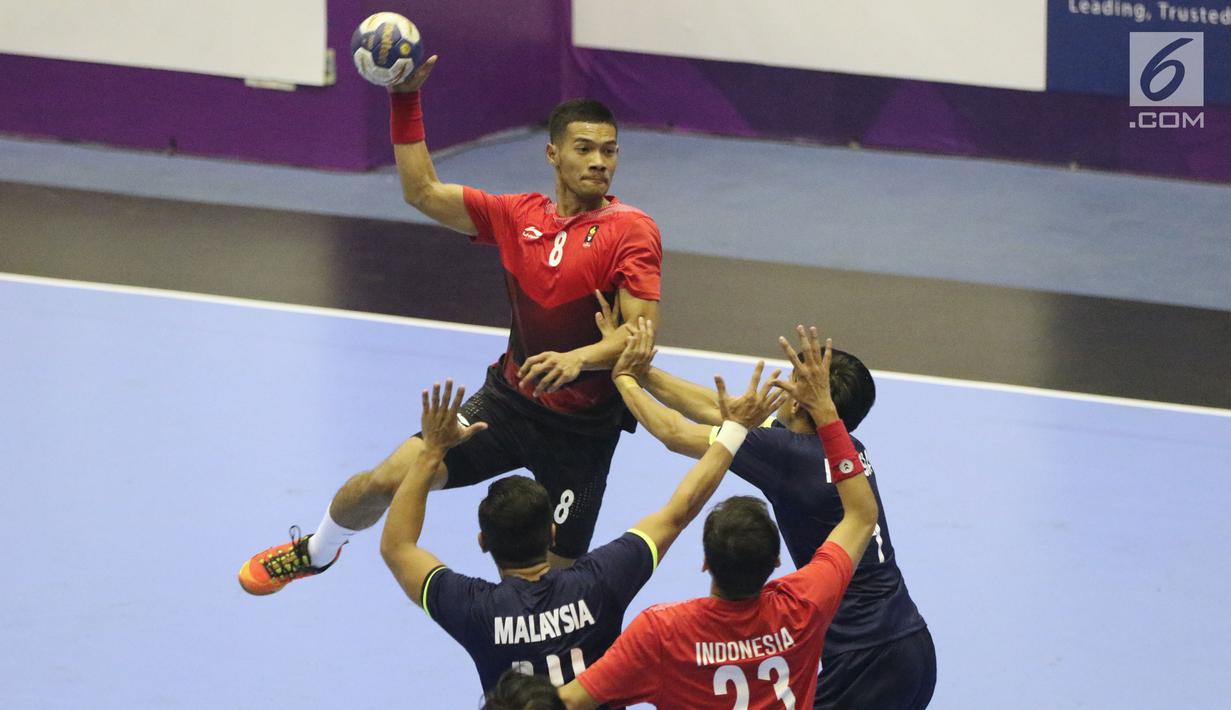 Pemain bola tangan Indonesia, Bagas (kiri) mencoba melempar bola ke gawang Malaysia pada penyisihan grup 3 bola tangan Asian Games 2018 di GOR PP POPKI, Jakarta, Minggu (26/8). Indonesia unggul 31-22. (Liputan6.com/Helmi Fithriansyah)