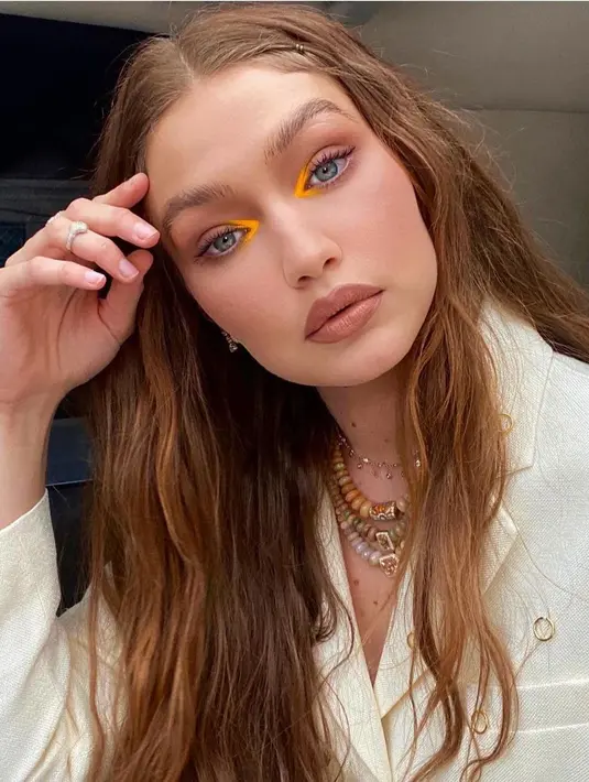 Sesekali tampil seru dan berani dengan pulasan ayeshadow bernuansa oranye. Warna ini memberikan kesan seru dan atraktif, namun tidak berlebih. Imbangi warna oranye dengan nude agar bisa dipakai saat kencan nanti. (Foto: Instagram/ Gigi Hadid)